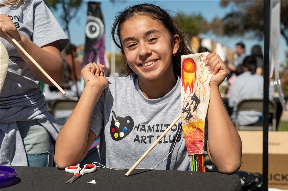 A student from Hamilton High School's art club showcases artwork she made.